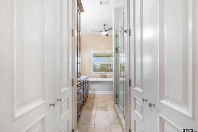 bathroom featuring tile patterned flooring, vanity, and plus walk in shower