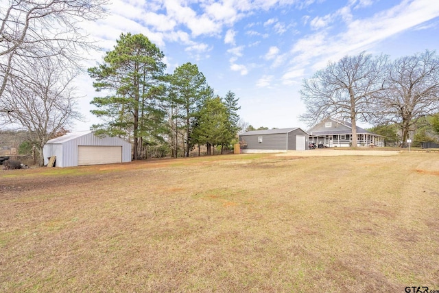 view of yard featuring a garage and an outdoor structure