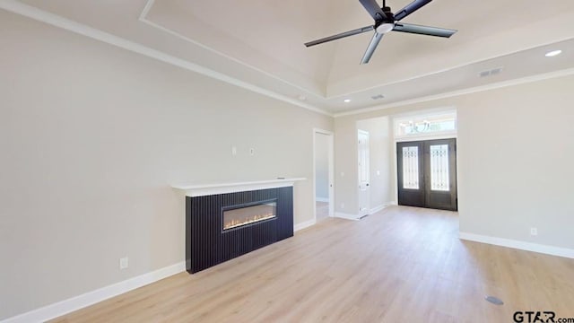 19346 Aida Dr, Flint, TX 75762 - unfurnished living room featuring light wood-style flooring, a glass covered fireplace, recessed lighting, a tray ceiling, and ornamental molding