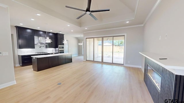 19346 Aida Dr, Flint, TX 75762 - kitchen with ceiling fan, tasteful backsplash, a tray ceiling, light wood finished floors, and black cooktop
