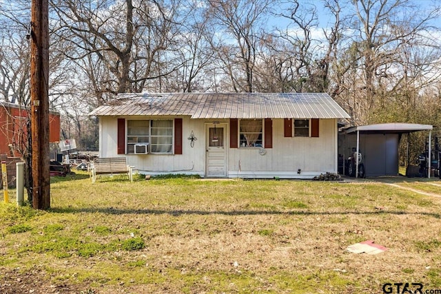 view of front of house featuring metal roof and a front yard