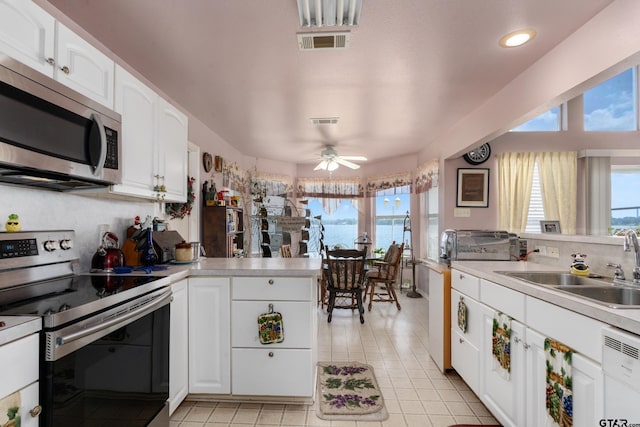15541 Precidio Cir, Malakoff, TX 75148 - kitchen with stainless steel appliances, a peninsula, light tile patterned floors, white cabinets, and recessed lighting