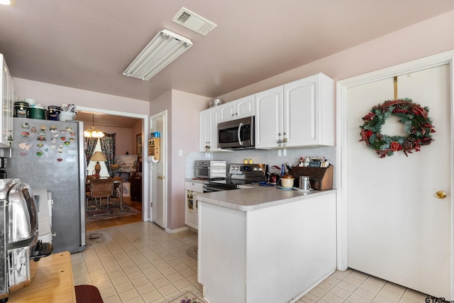 15541 Precidio Cir, Malakoff, TX 75148 - kitchen with stainless steel appliances, light tile patterned floors, a chandelier, white cabinetry, and a peninsula