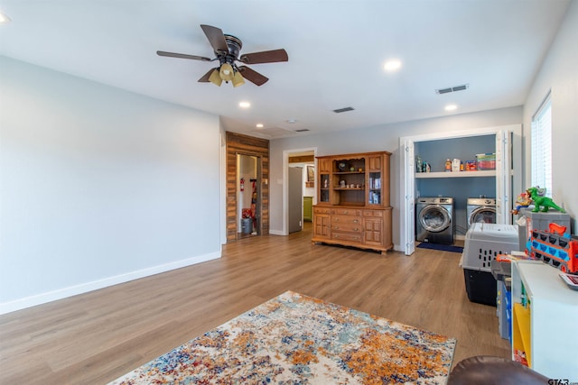 interior space featuring ceiling fan, light hardwood / wood-style flooring, and independent washer and dryer