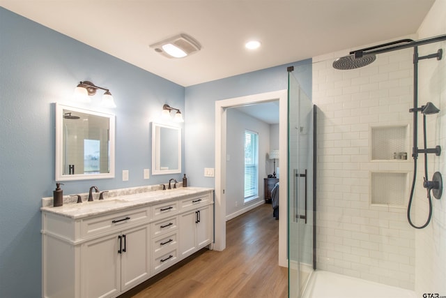 bathroom featuring vanity, wood-type flooring, and a shower with door