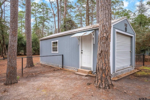 view of outbuilding featuring fence and an outdoor structure