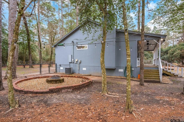 view of side of property with stairway, an outdoor fire pit, a gate, crawl space, and fence