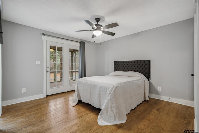 bedroom featuring baseboards, ceiling fan, wood finished floors, and access to exterior