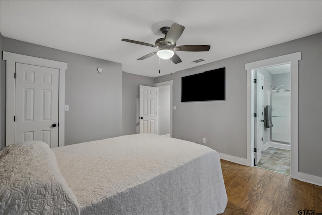 bedroom featuring visible vents, connected bathroom, ceiling fan, wood finished floors, and baseboards