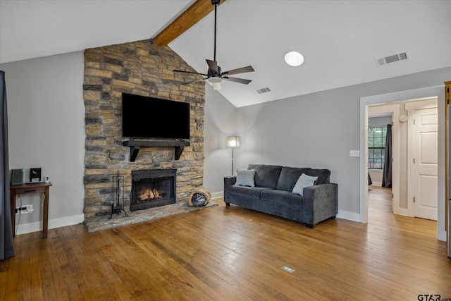 living area with a ceiling fan, visible vents, a fireplace, and lofted ceiling with beams