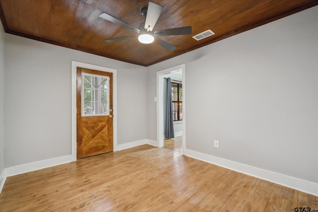 spare room with light wood finished floors, visible vents, and baseboards