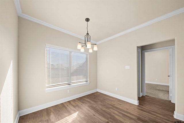 spare room featuring hardwood / wood-style floors, ornamental molding, and a notable chandelier