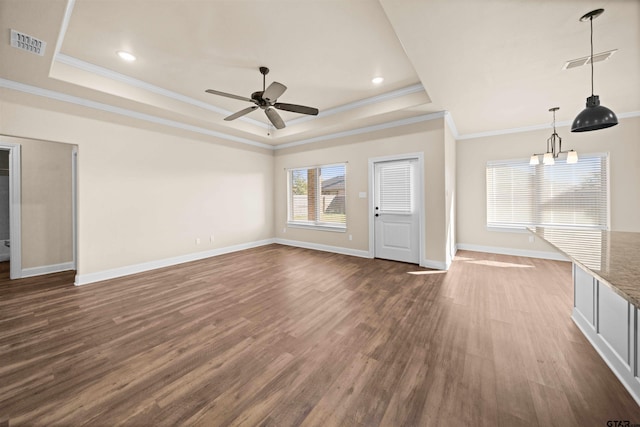 unfurnished living room with a raised ceiling, crown molding, and dark wood-type flooring