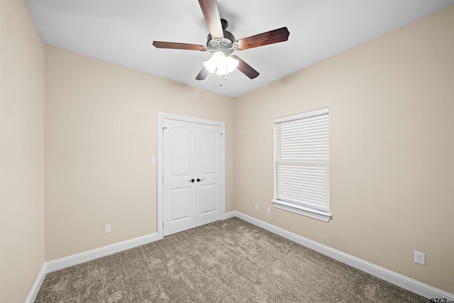 carpeted spare room featuring ceiling fan