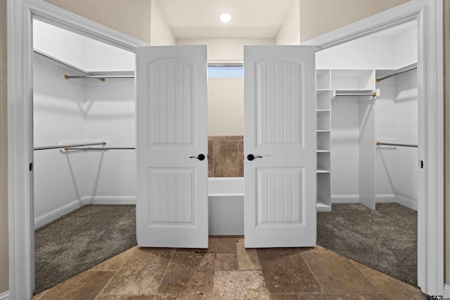 walk in closet with dark carpet