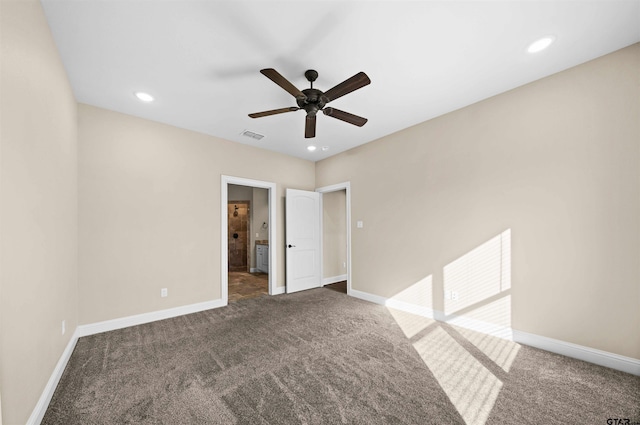 empty room with ceiling fan and dark carpet