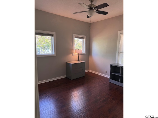 unfurnished room with dark wood-type flooring and ceiling fan