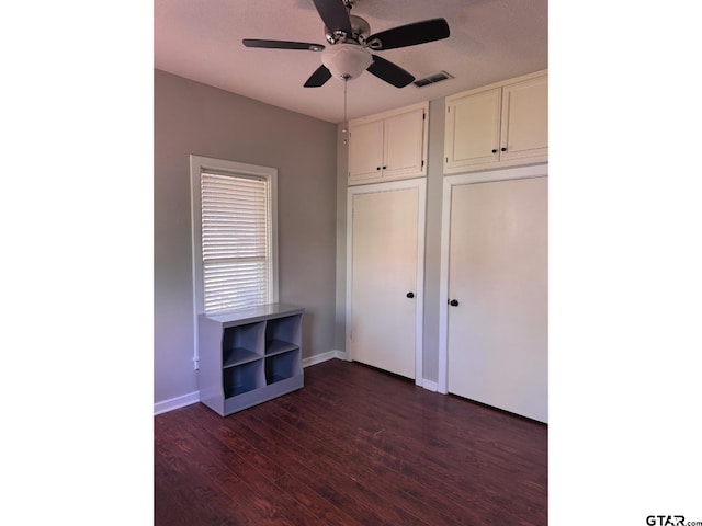 unfurnished bedroom with dark wood-type flooring and ceiling fan