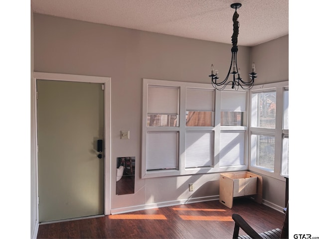 dining room featuring a textured ceiling, dark hardwood / wood-style floors, and a chandelier