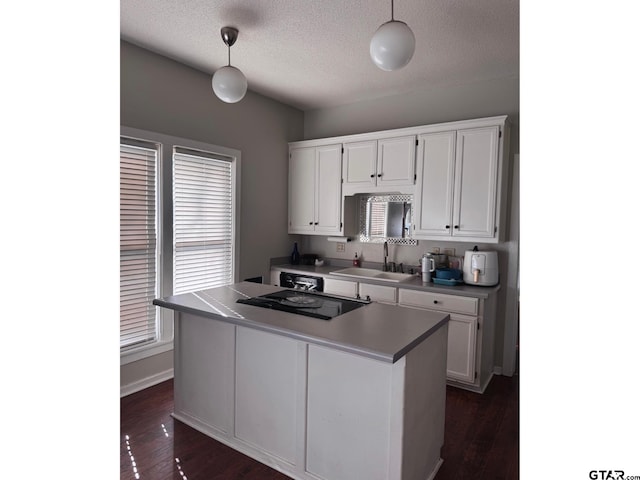 kitchen with white cabinetry, sink, dark hardwood / wood-style floors, and hanging light fixtures