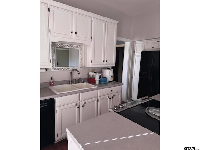 kitchen with white cabinetry, sink, and black appliances