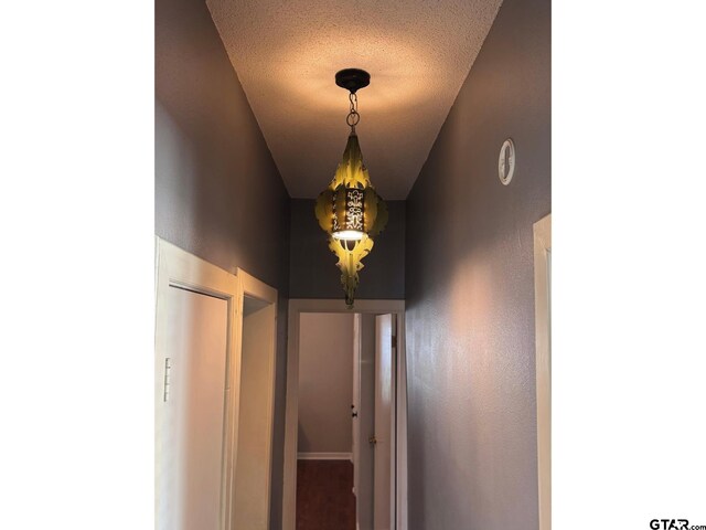 hallway with a textured ceiling