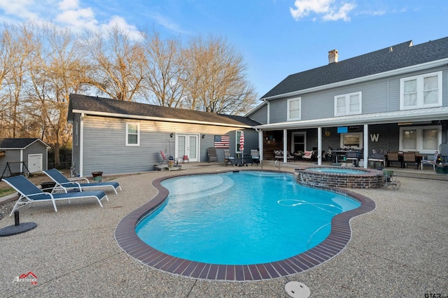 view of pool with french doors, a patio, an outbuilding, and a pool with connected hot tub