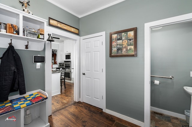 mudroom with dark wood finished floors and baseboards