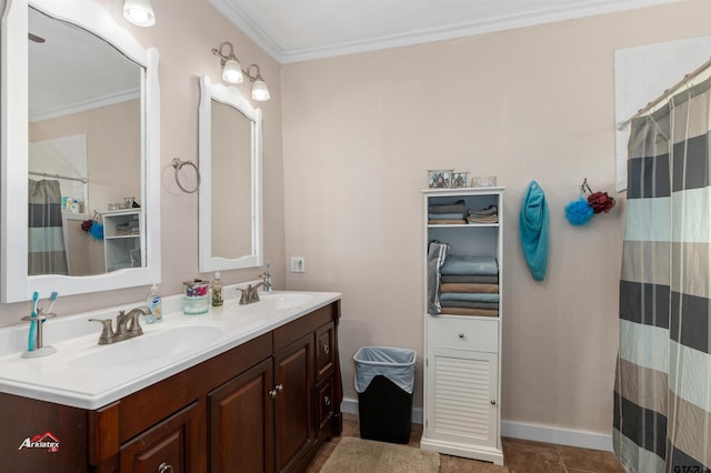 bathroom featuring double vanity, crown molding, baseboards, and a sink