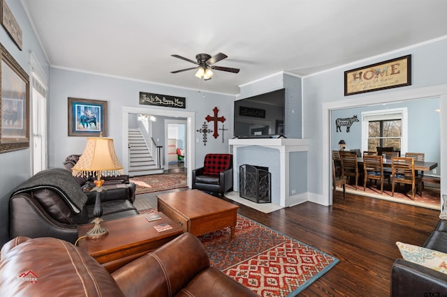 living area featuring plenty of natural light, a brick fireplace, crown molding, and hardwood / wood-style flooring