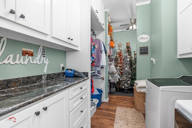 laundry area featuring washer and dryer, cabinet space, dark wood-type flooring, and a ceiling fan