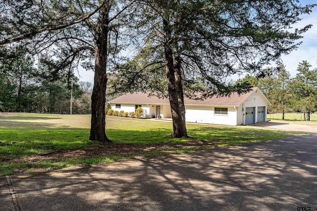 view of front facade with a garage, concrete driveway, and a front yard