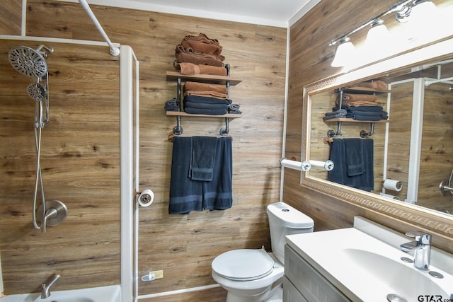 bathroom featuring vanity, wooden walls, and toilet