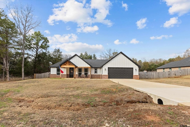 modern inspired farmhouse with a garage, covered porch, and a front lawn