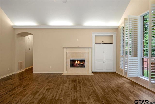 5405 Ashbury Ct, Tyler, TX 75703 - unfurnished living room featuring wood finished floors, a tiled fireplace, and plenty of natural light