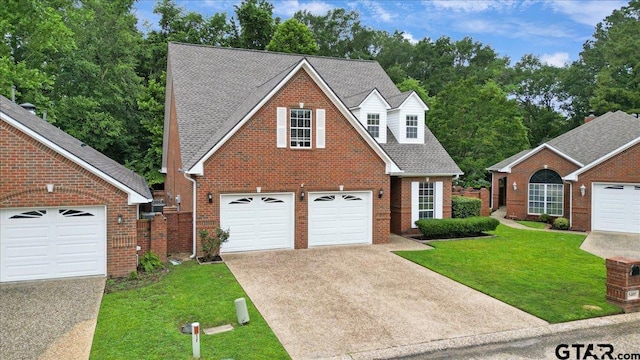 5405 Ashbury Ct, Tyler, TX 75703 - traditional-style house with driveway, a front yard, brick siding, and view of scattered trees
