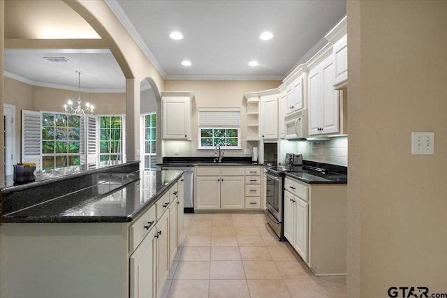 5405 Ashbury Ct, Tyler, TX 75703 - kitchen with appliances with stainless steel finishes, open shelves, backsplash, arched walkways, and crown molding