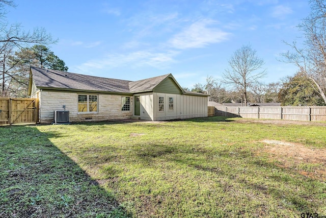 back of house with central AC and a lawn