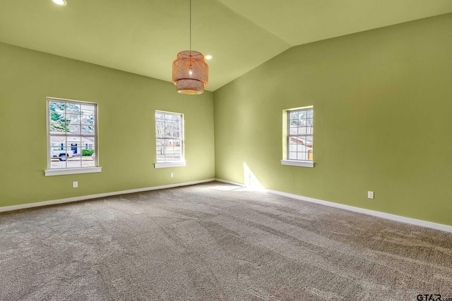 unfurnished room with carpet, vaulted ceiling, and plenty of natural light