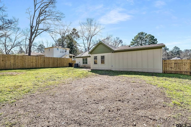 back of property featuring a lawn and central AC