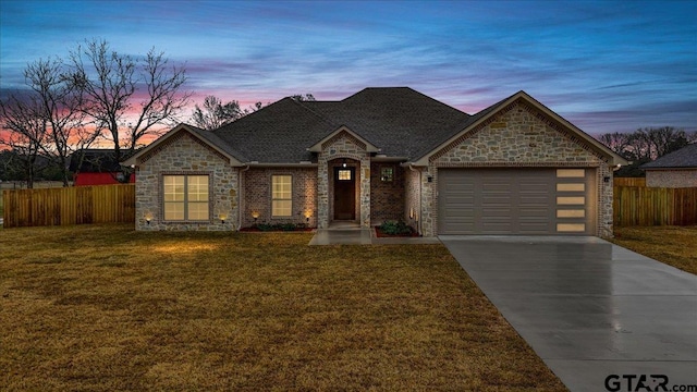 single story home with a garage and a yard