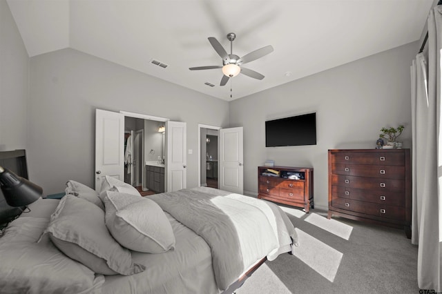 carpeted bedroom featuring ceiling fan, lofted ceiling, and ensuite bathroom