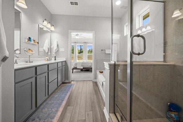 bathroom with ceiling fan, hardwood / wood-style floors, vanity, and an enclosed shower