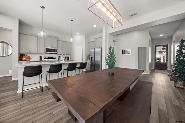 dining area featuring sink and dark wood-type flooring