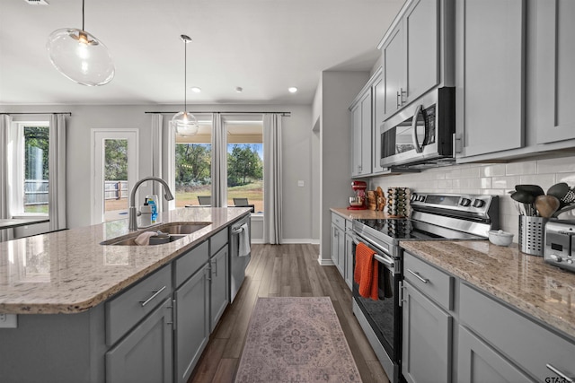 kitchen with gray cabinetry, sink, stainless steel appliances, dark hardwood / wood-style floors, and a kitchen island with sink