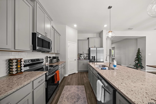 kitchen featuring light stone countertops, sink, dark wood-type flooring, gray cabinets, and appliances with stainless steel finishes