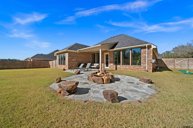 back of property with a lawn, a patio area, and an outdoor fire pit