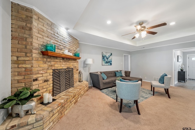 7411 Hollyoak Dr, Tyler, TX 75703 - carpeted living room with a fireplace, ceiling fan, a tray ceiling, and recessed lighting