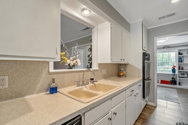 7411 Hollyoak Dr, Tyler, TX 75703 - kitchen featuring crown molding, white cabinets, decorative backsplash, light countertops, and stainless steel double oven