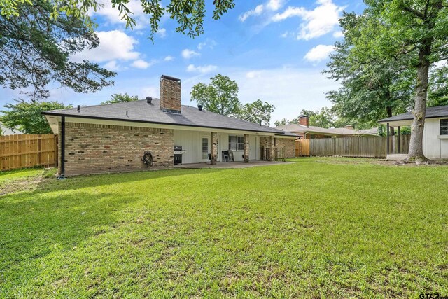 7411 Hollyoak Dr, Tyler, TX 75703 - rear view of house with a patio area, a fenced backyard, a chimney, and brick siding